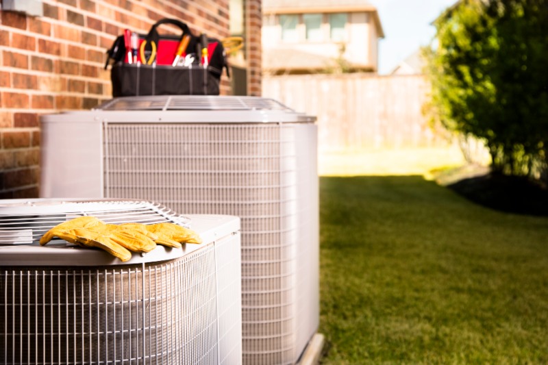 Tools and gloves beside an HVAC unit in a Glendora, CA yard